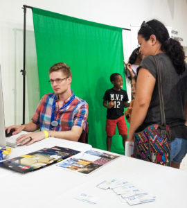 Young Man at Computer with Children in the Background